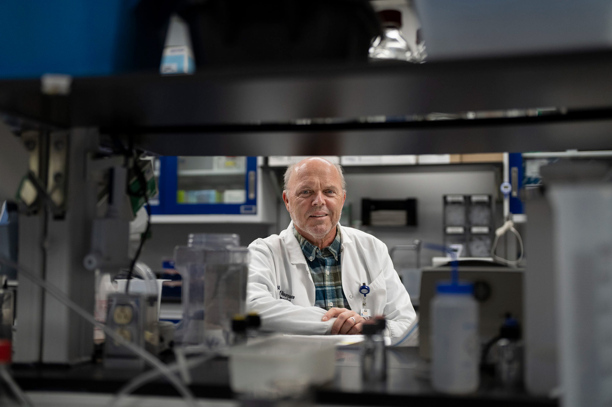 Harald Sontheimer looking at the camera through some laboratory shelves.