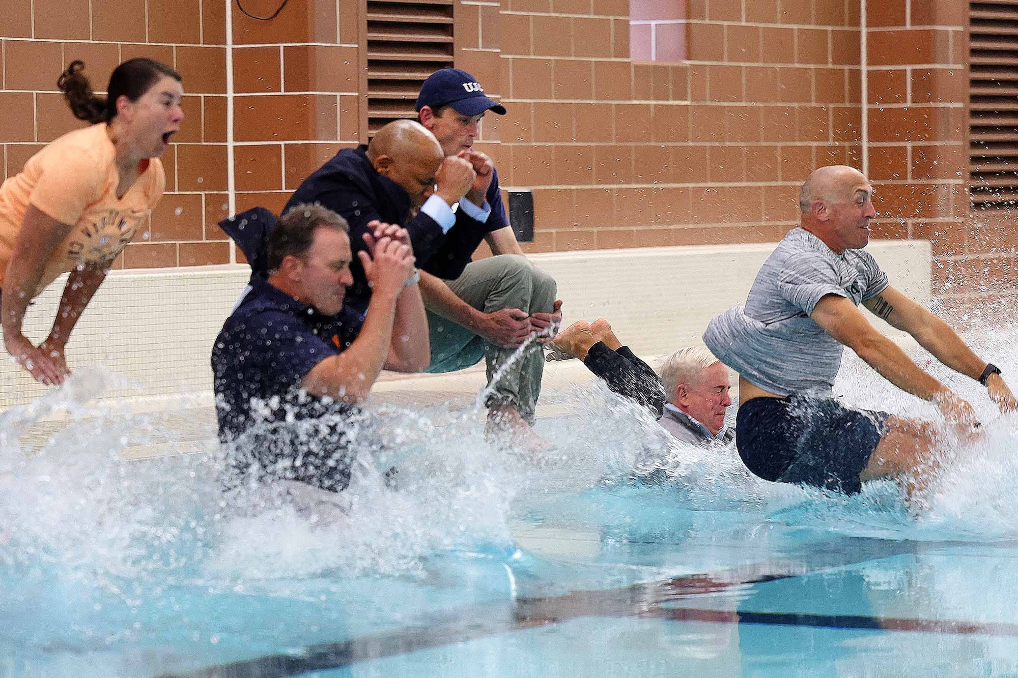 Portrait of people jumping in the pool.