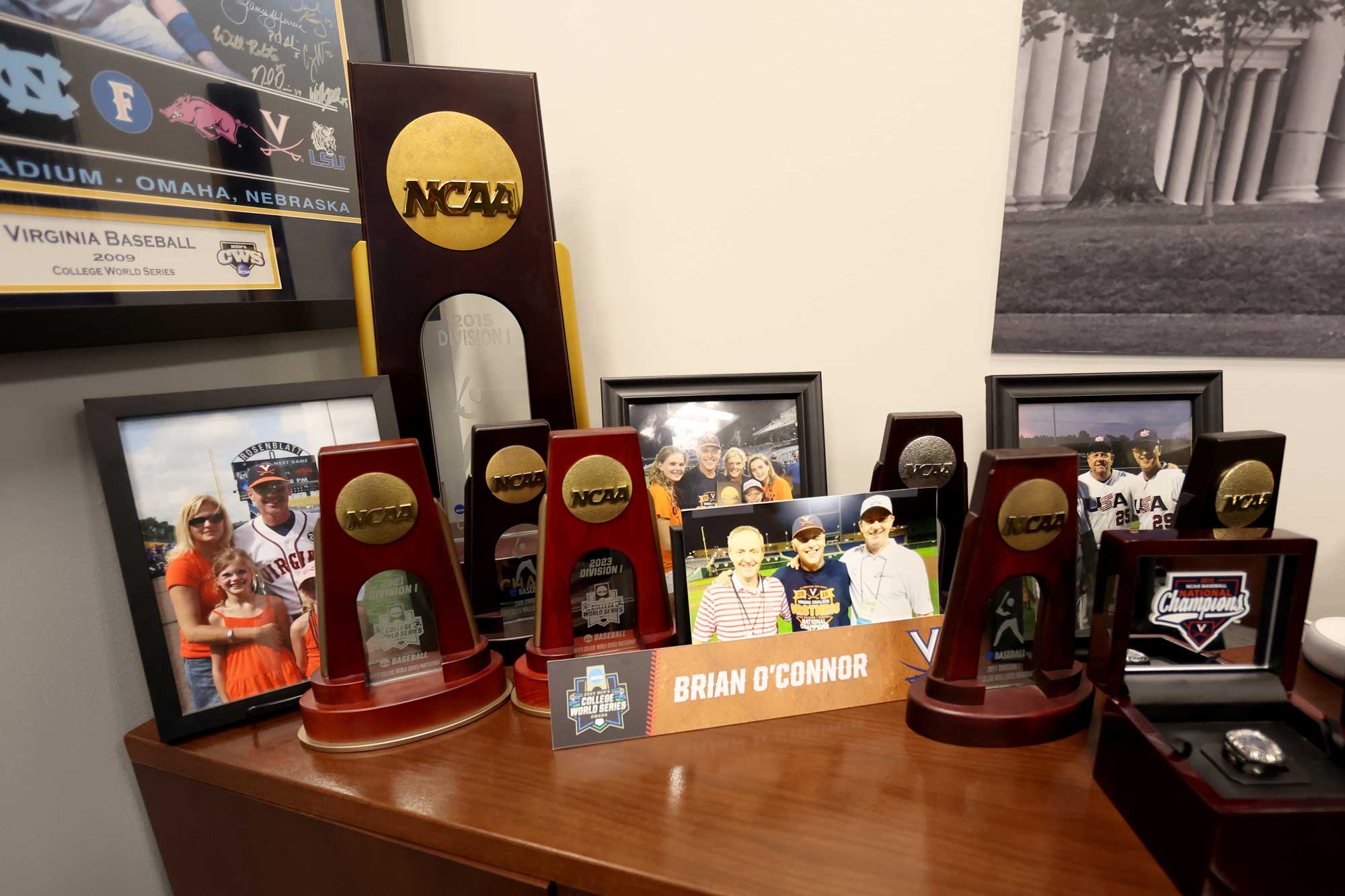 A collection of NCAA championship trophies, photos and a ring