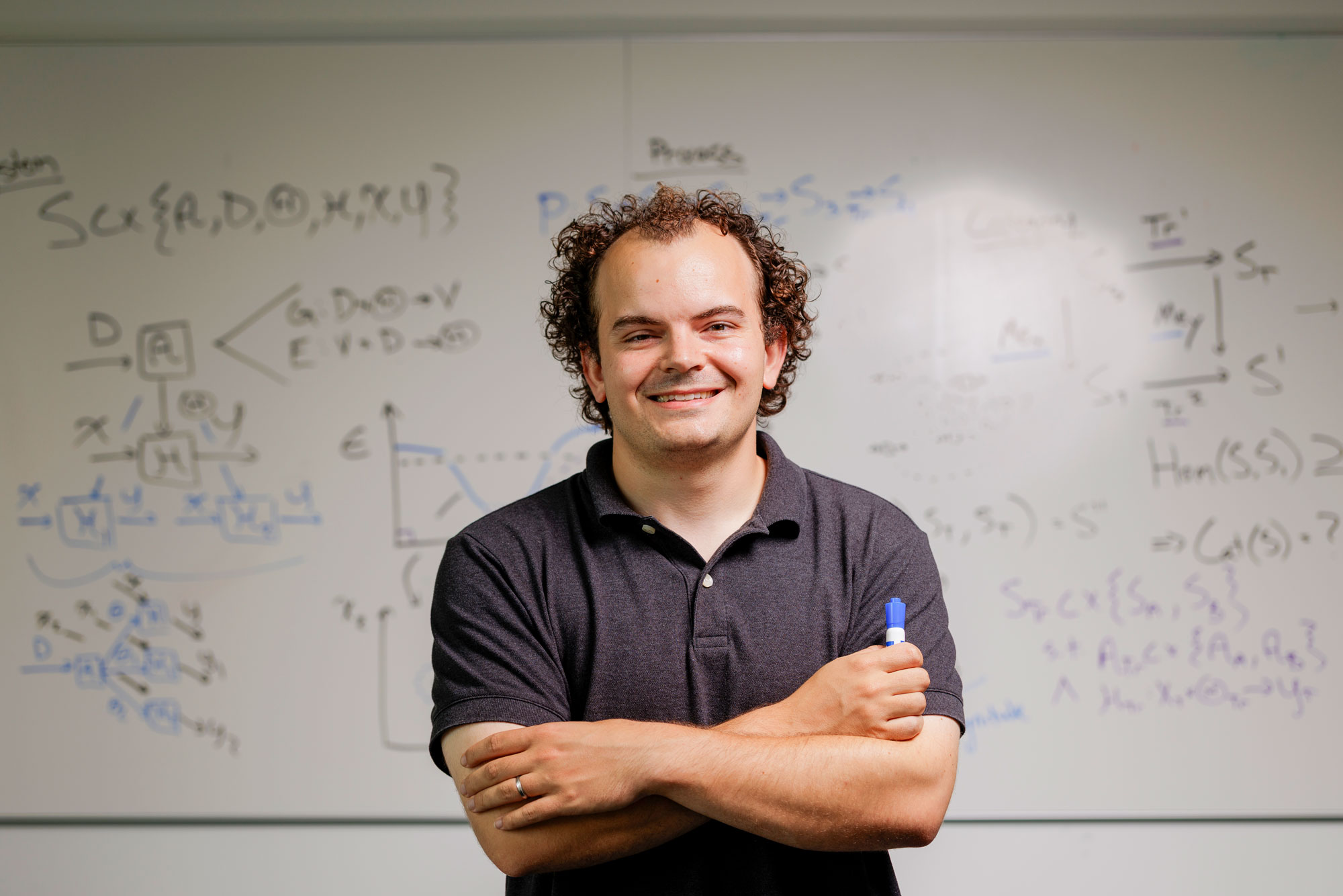 UVA professor of Data Science Tyler Cody in front of a whiteboard covered in code and formulas