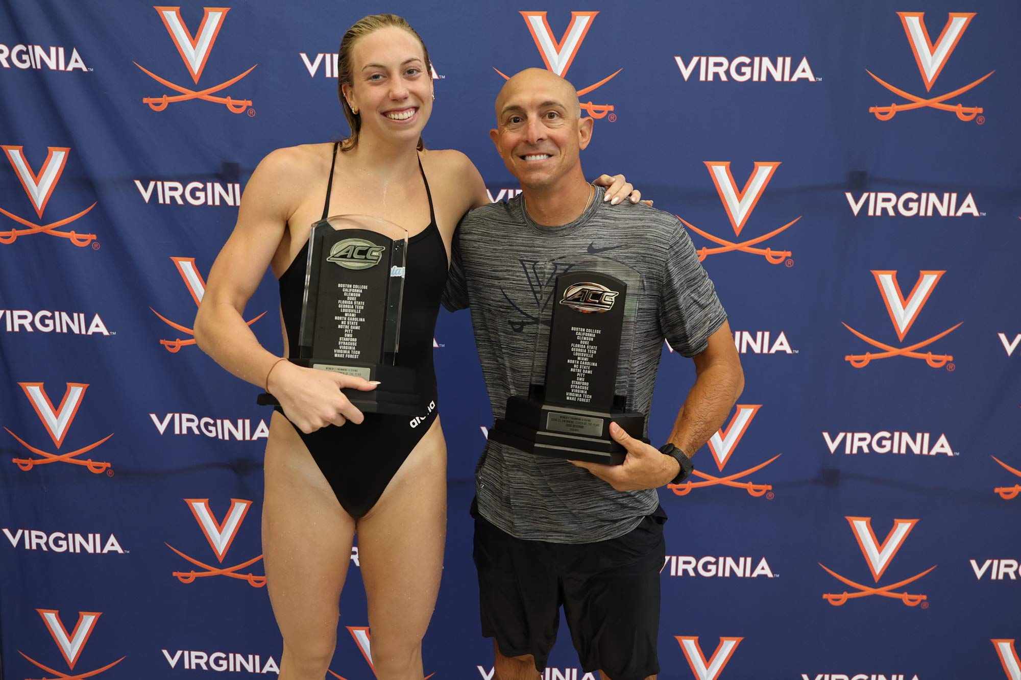 Gretchen Walsh and Todd DeSorbo holding trophies after a competition