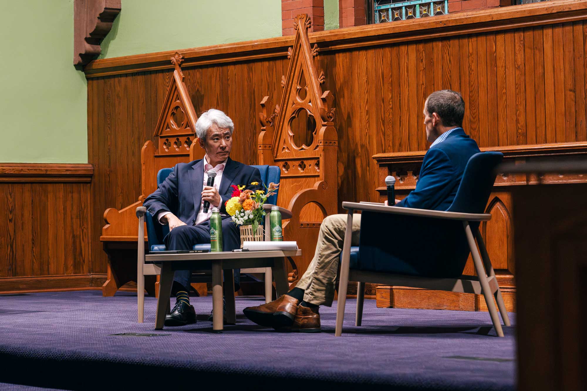 Kim sits parallel to President Ryan as they talk in the University chapel