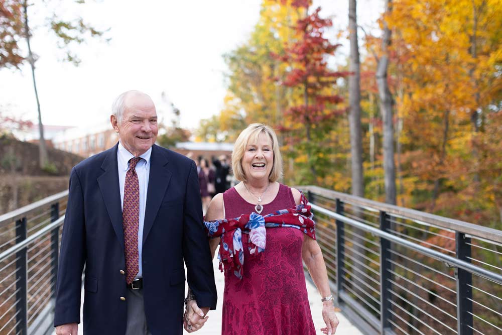 Darden alum David LaCross and his wife Kathy walk on a colorful fall day