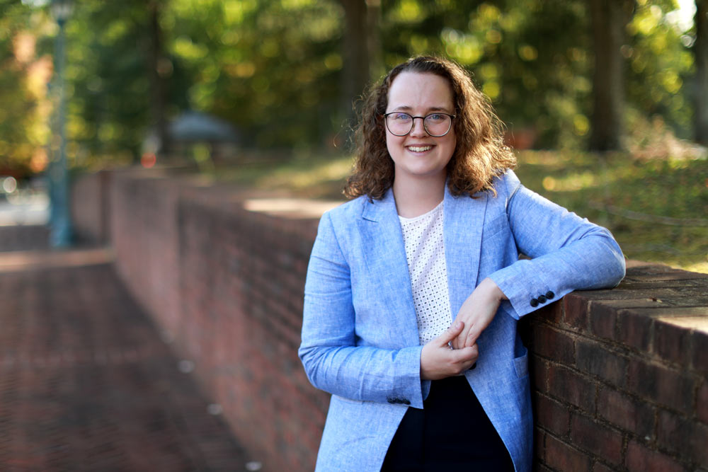 Gorman leaning on a brick wall for a portrait outside