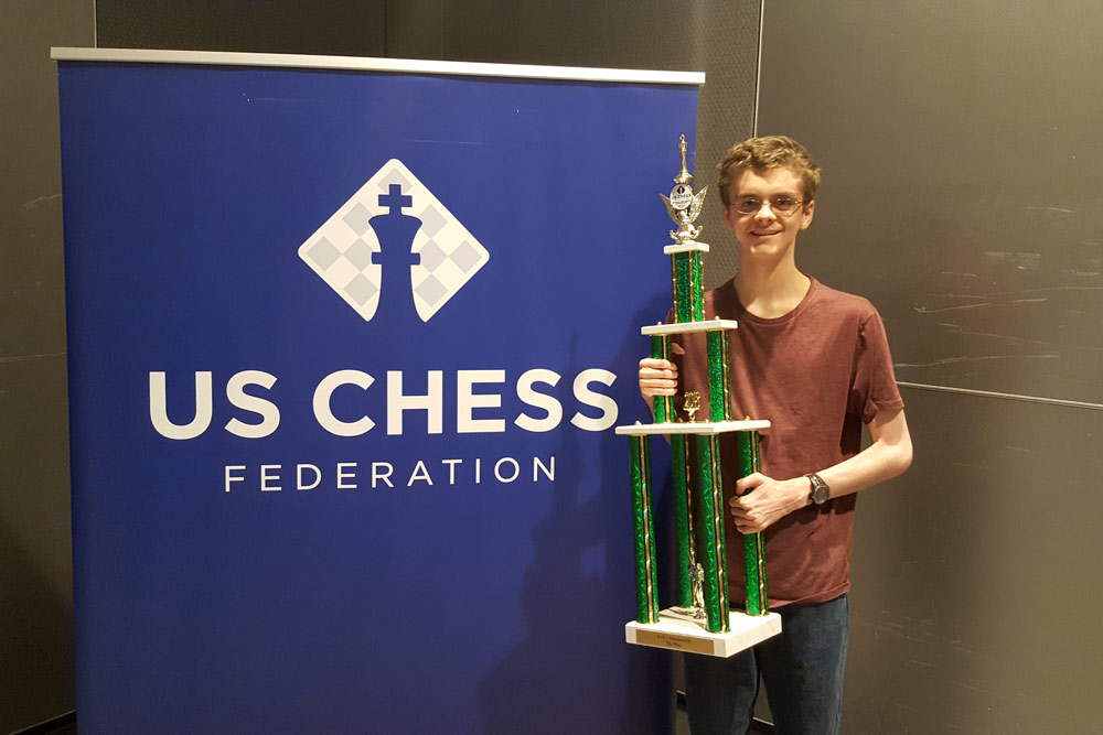 Morefield competed in the 2015 High School National Chess Tournament and stands with the trophy he won.