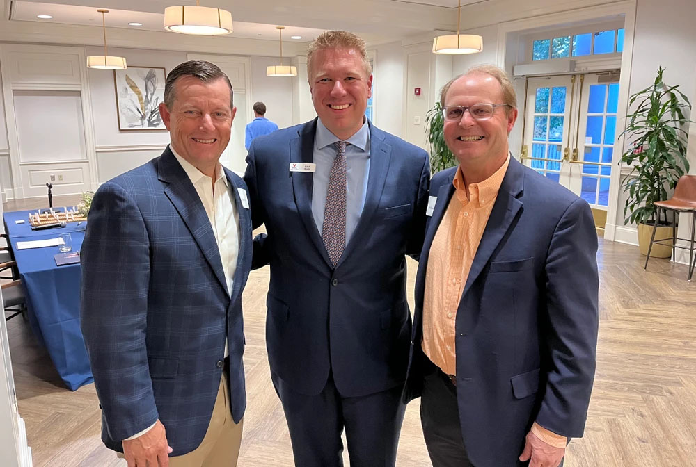 Virginia Athletics Foundation Executive Director Kevin Miller, center, in a suite posing for a group picture