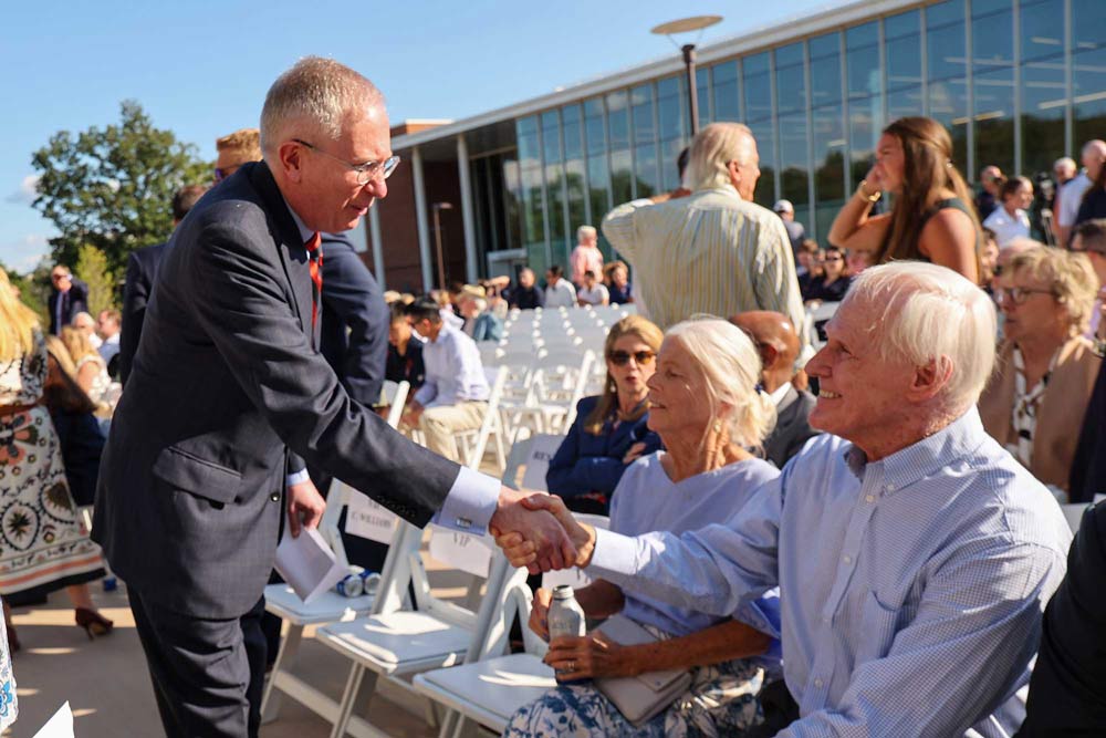 UVA interim president Paul Mahoney shakes hands with audience members at the opening ceremony of the UVA olympic sports facility