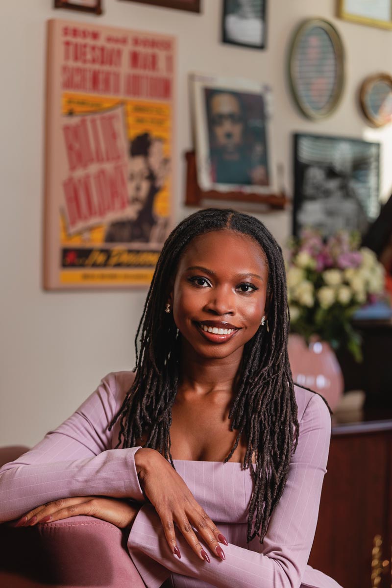 Isi sitting in front of a Billie Holiday poster.