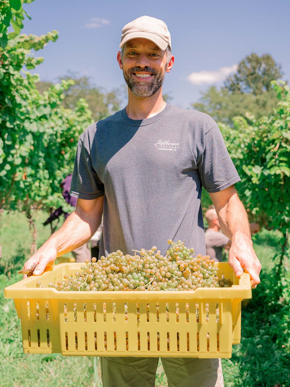 Portrait of Chris Ritzcovan carrying a basket of grapes