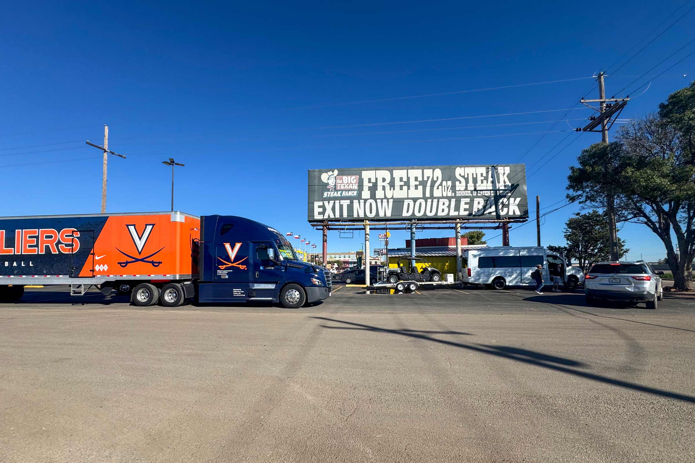 Side view of UVA football equipment truck stops at The Big Texan restaurant.