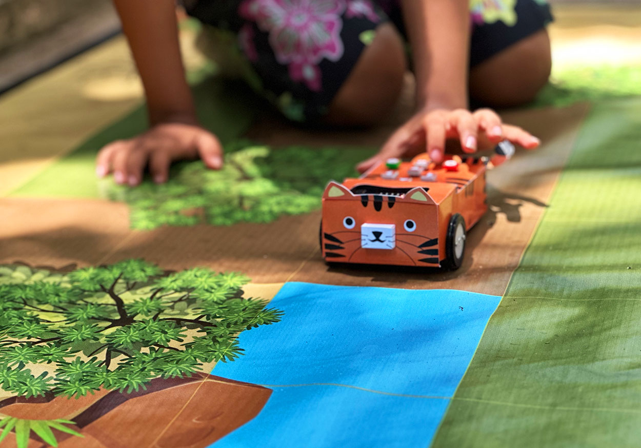 Close up of a child playing with a robot car