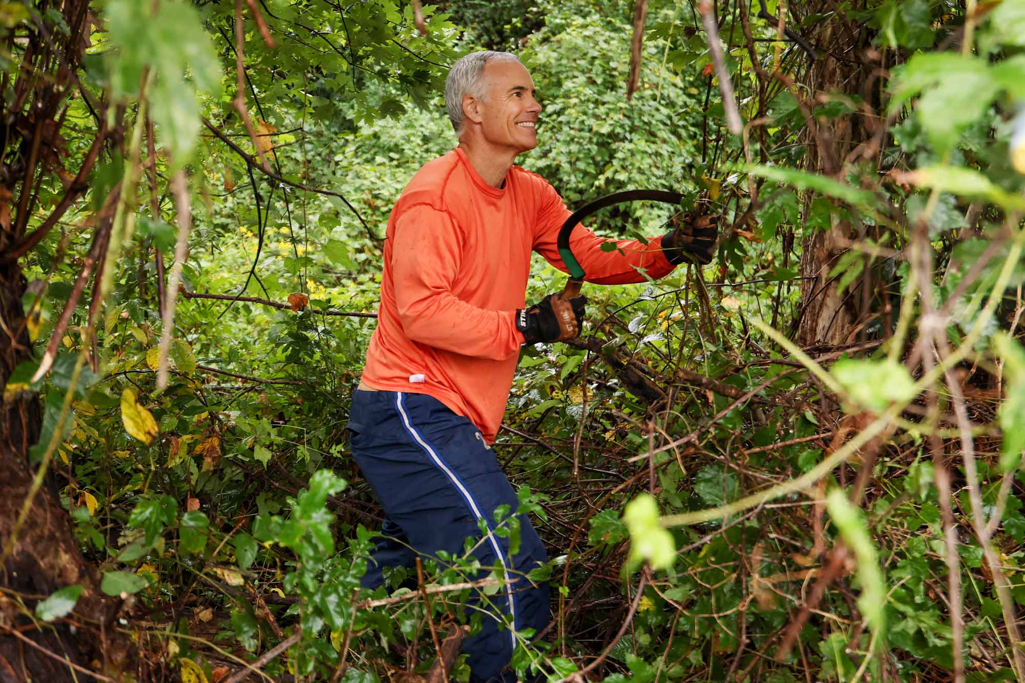 Lars Tiffany trimming overgrowth at New Roots Farm