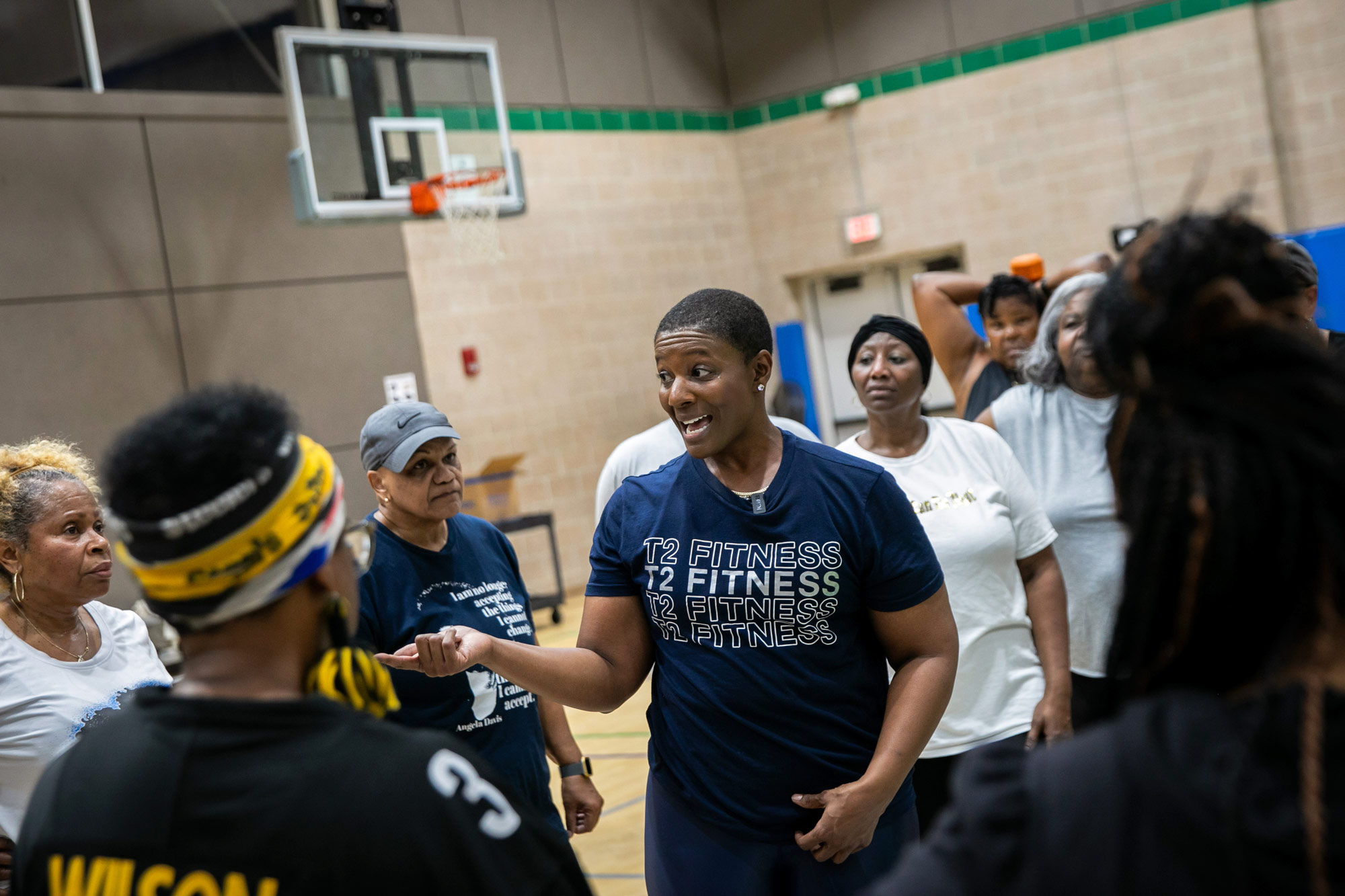 Turnbull talking with students in a basketball court