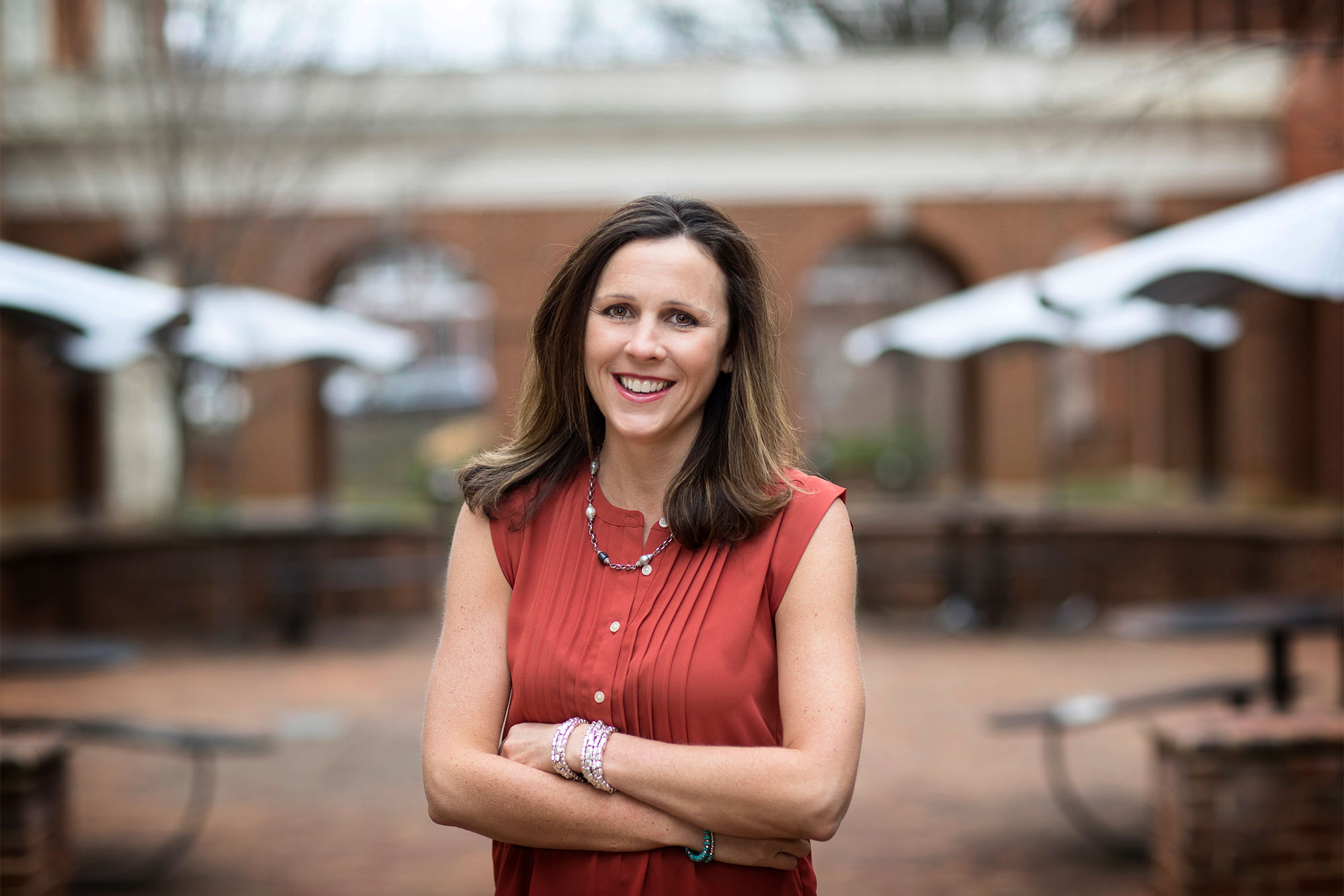 Portrait of Catherine Bradshaw standing in a courtyard beside the UVA rotunda