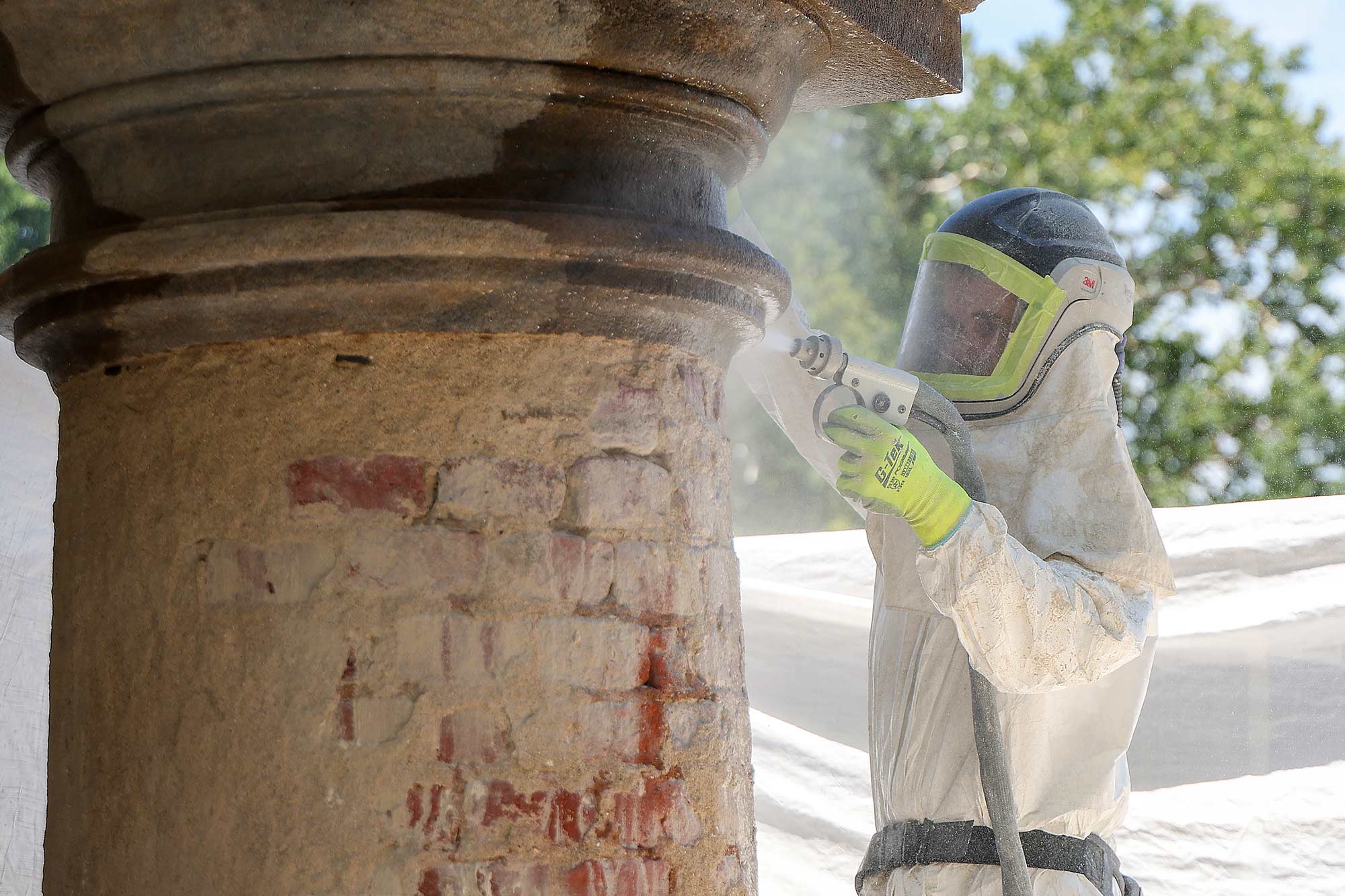 Brent Ryder removing paint layers from column capitals and bases on UVA Pavilion 1
