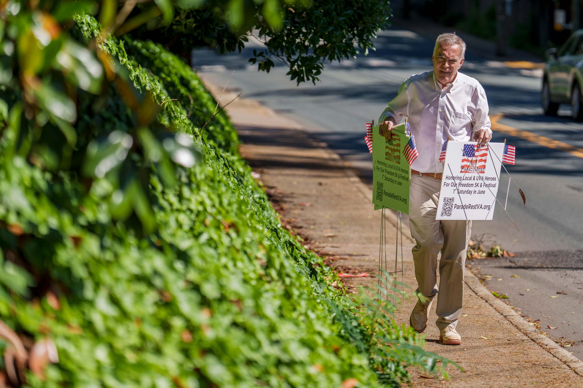 Greg Saathoff carrying yard signs about Memorial Day