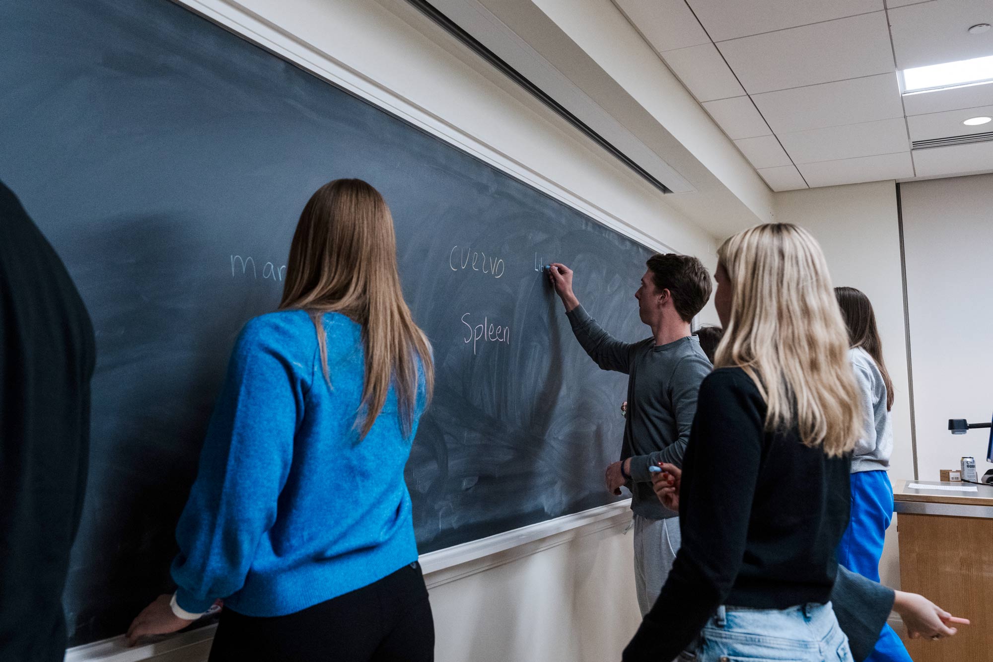 Students write on a chalkboard