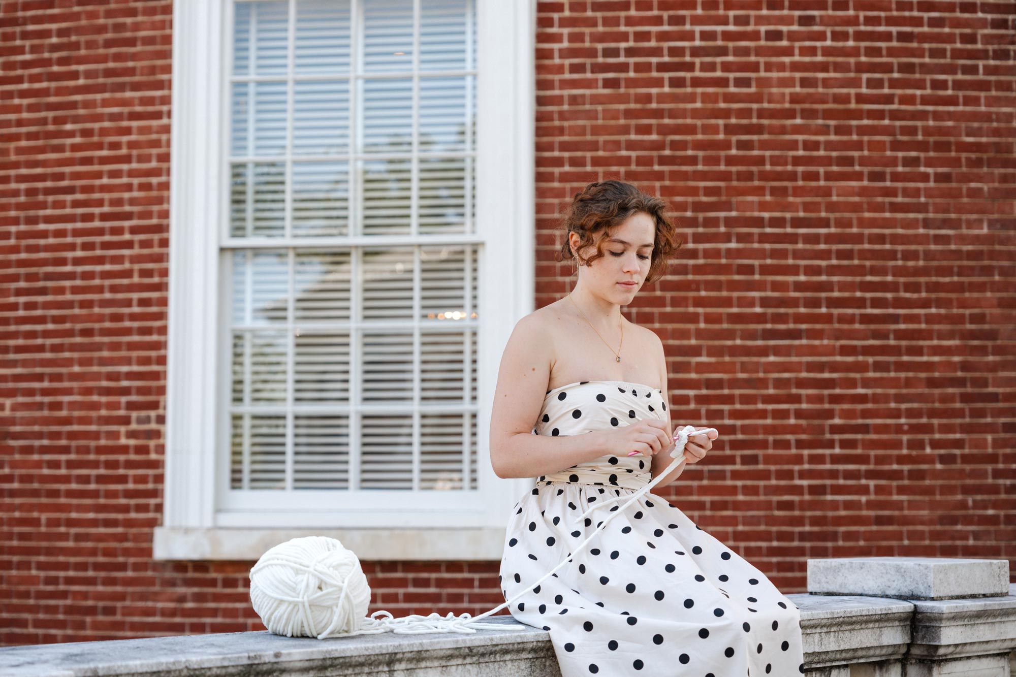 Portrait of Polina Andreeva crocheting toys.