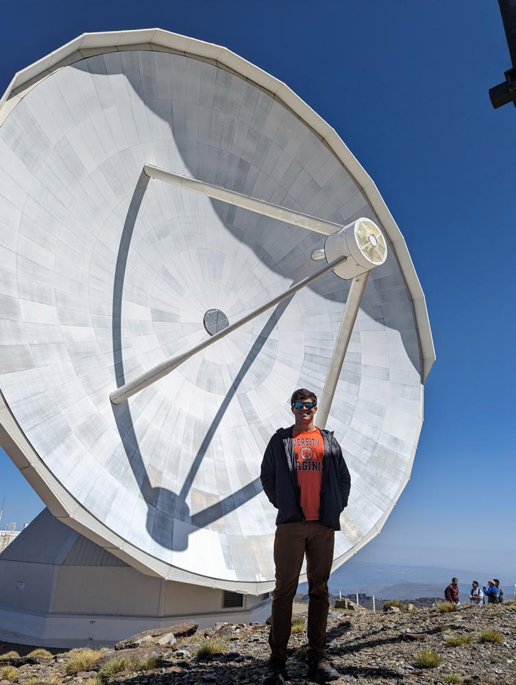 Sam Crowe standing in front of the IRAM 30-meter radio telescope