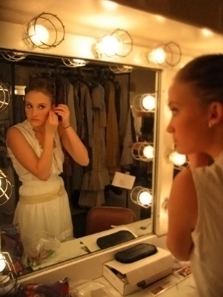 Walters puts on earrings backstage before a performance at UVA 