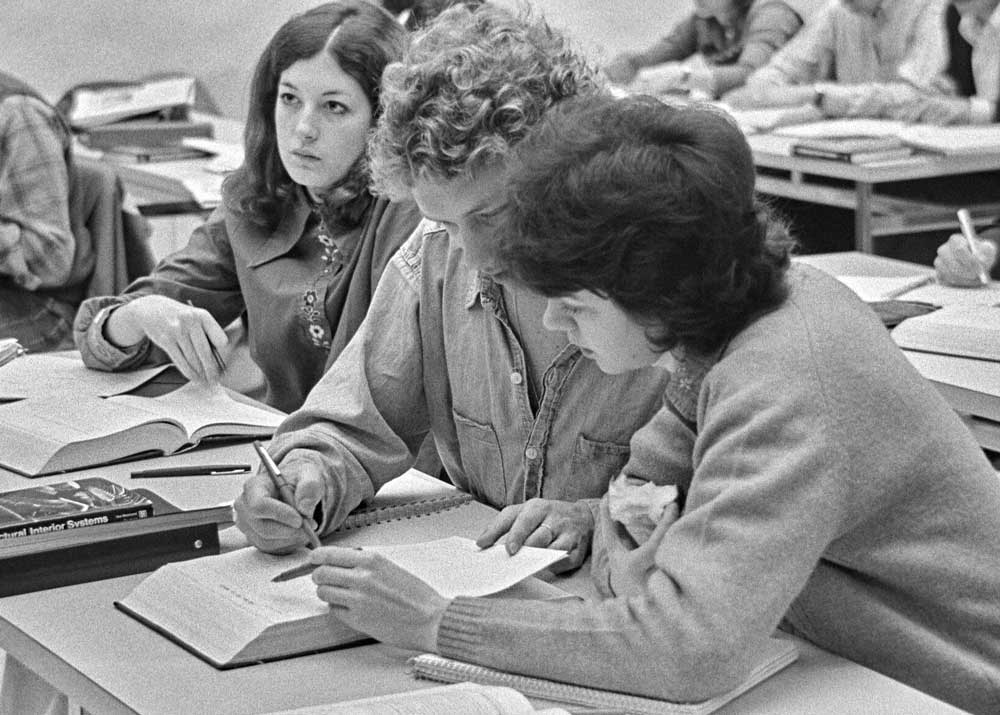 male and female students reading from a textbook