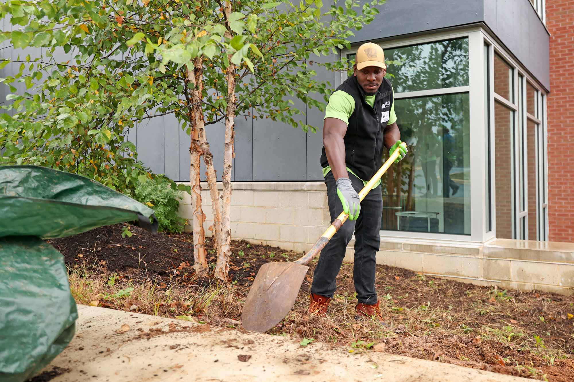 Raymond Brown using a shovel to clear a garden bed