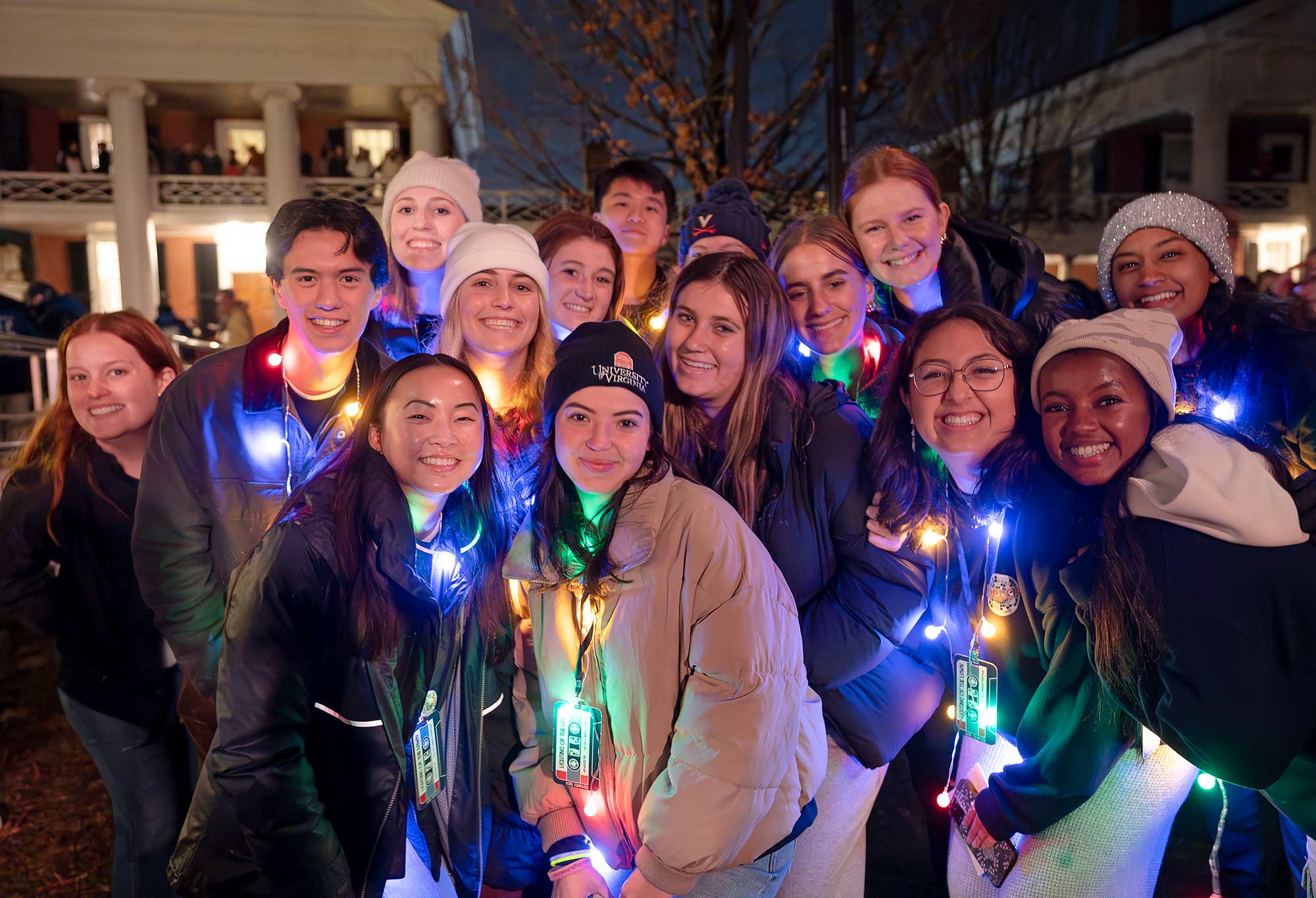 Group portrait of students wearing illuminated lights around their necks during the Lighting of the Lawn.