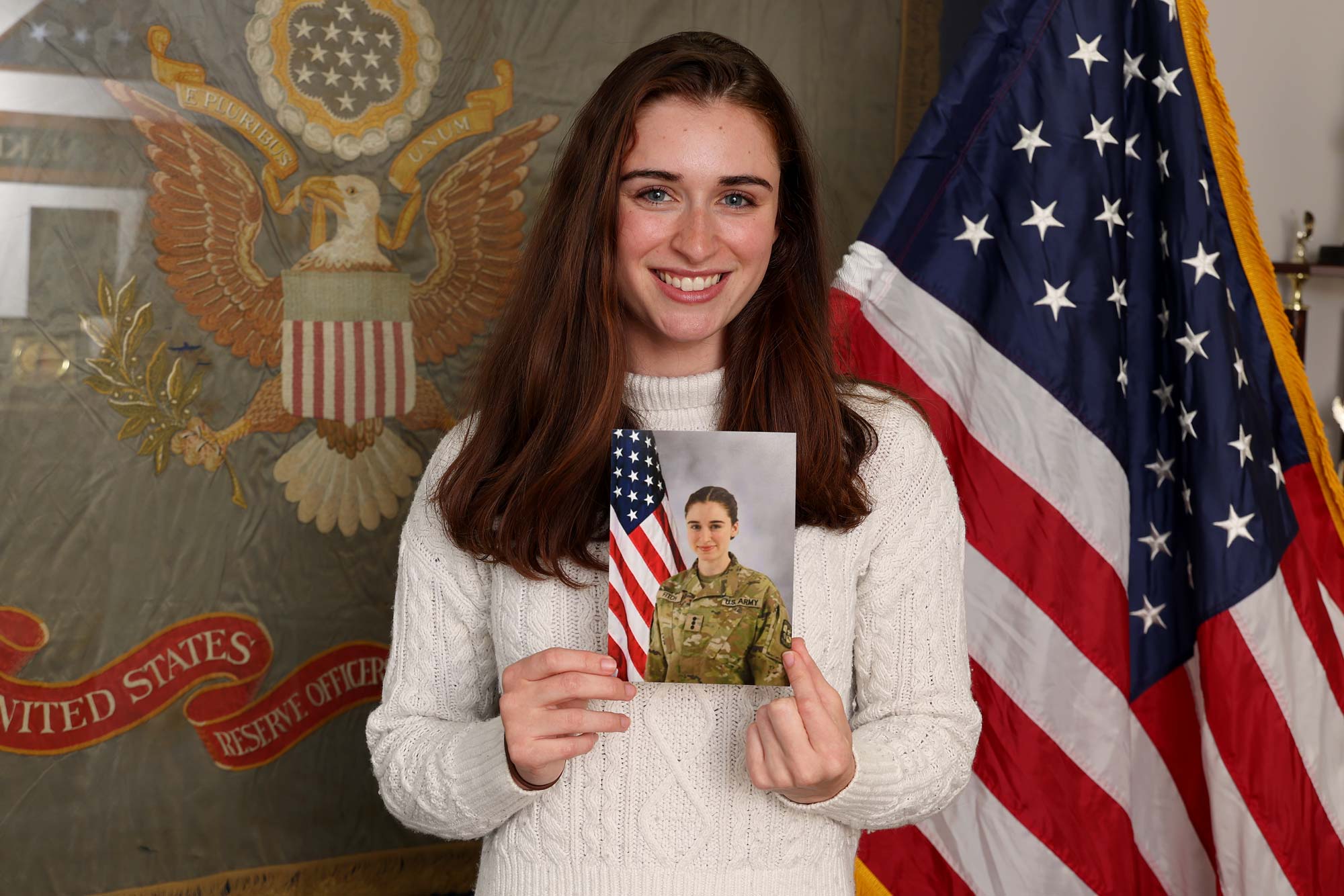 Rebecca Fitch holding a picture of herself in uniform