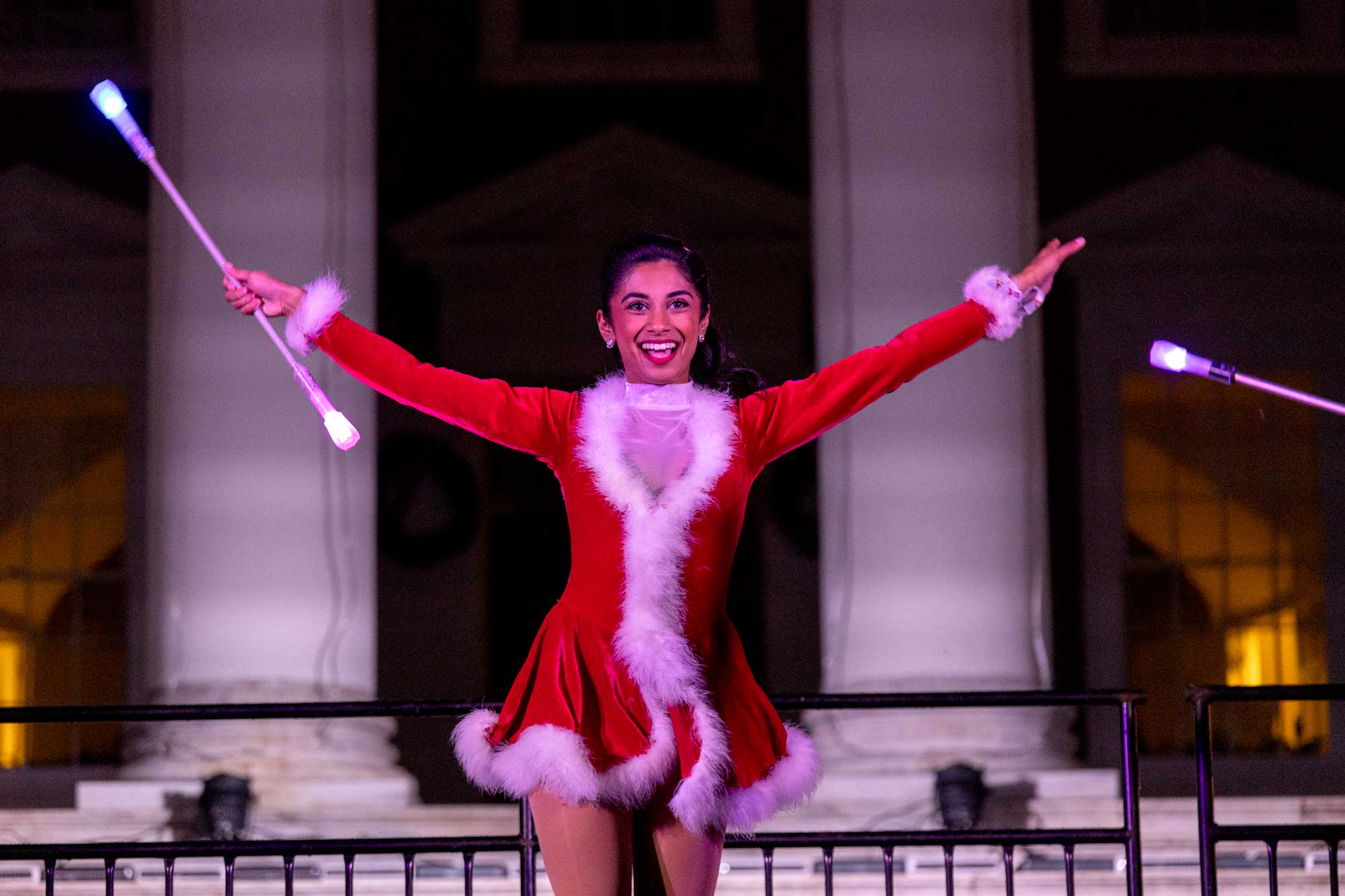 Ishita Bakski performing a baton routine on stage in front of the UVA Rotunda