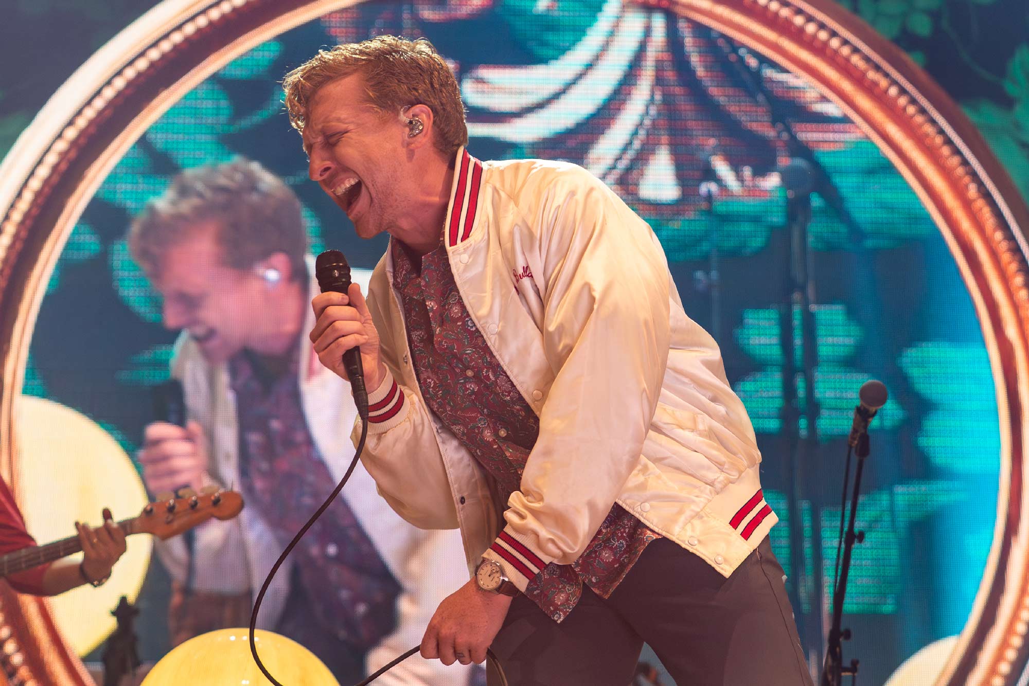 Tyler Childers performing at UVA's John Paul Jones Arena in front of a concert projection video