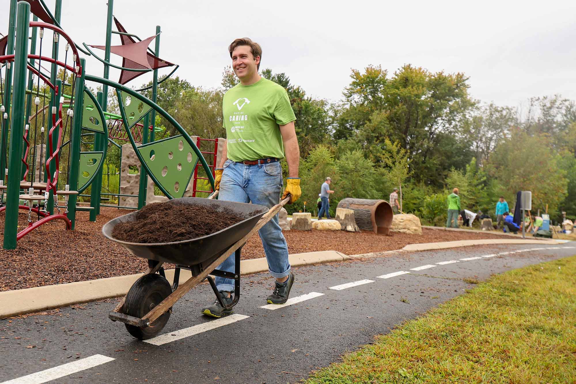 Thomas King pushing a wheelbarrow of soil at a playground