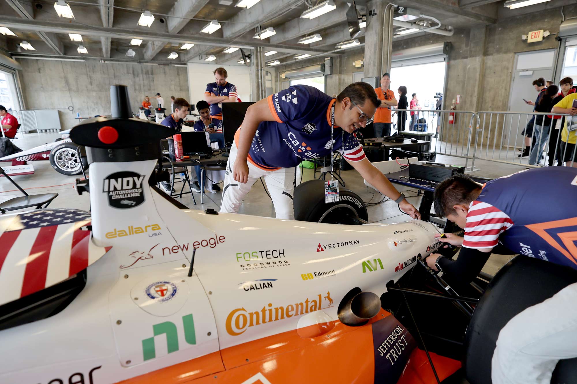 Professor Madhur Behl and a member of the Cavalier Autonomous Racing Team work on the autonomous racecar at Indianapolis Motor Speedway.