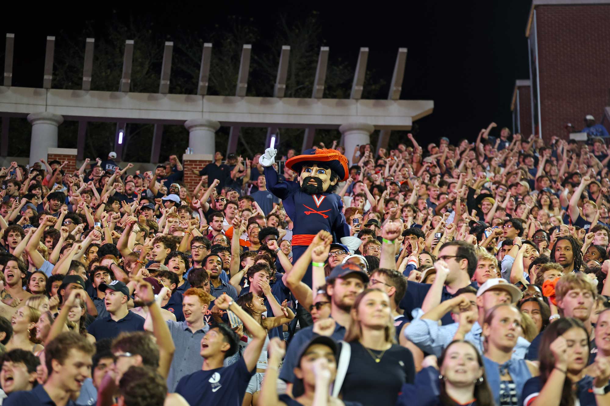 Portrait of Cavman rises above the sea of students spread across the Scott Stadium hill.