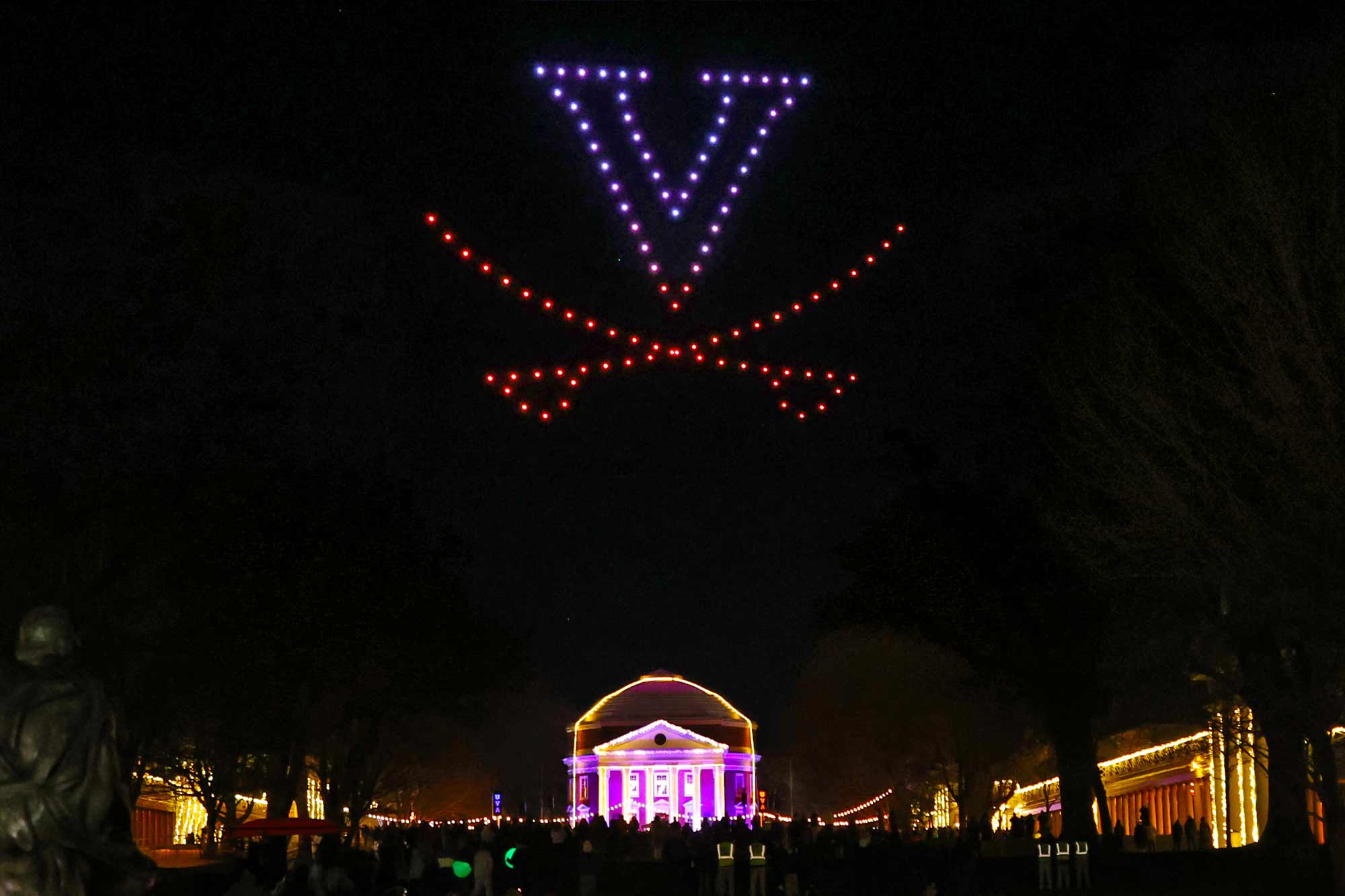 Drones light a V saber in the sky over a lite up Lawn and Rotunda at the 2024 Lighting of the Lawn