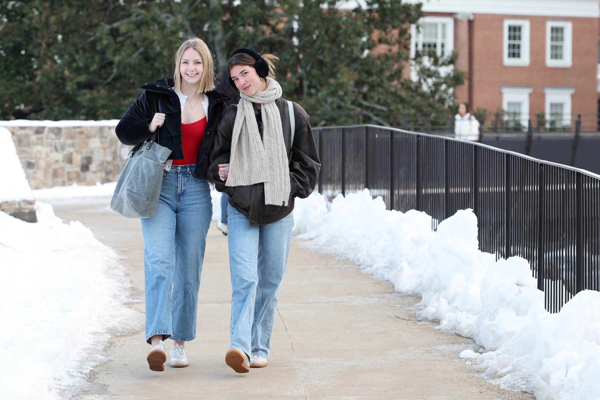 Two students walking down a sidewalk