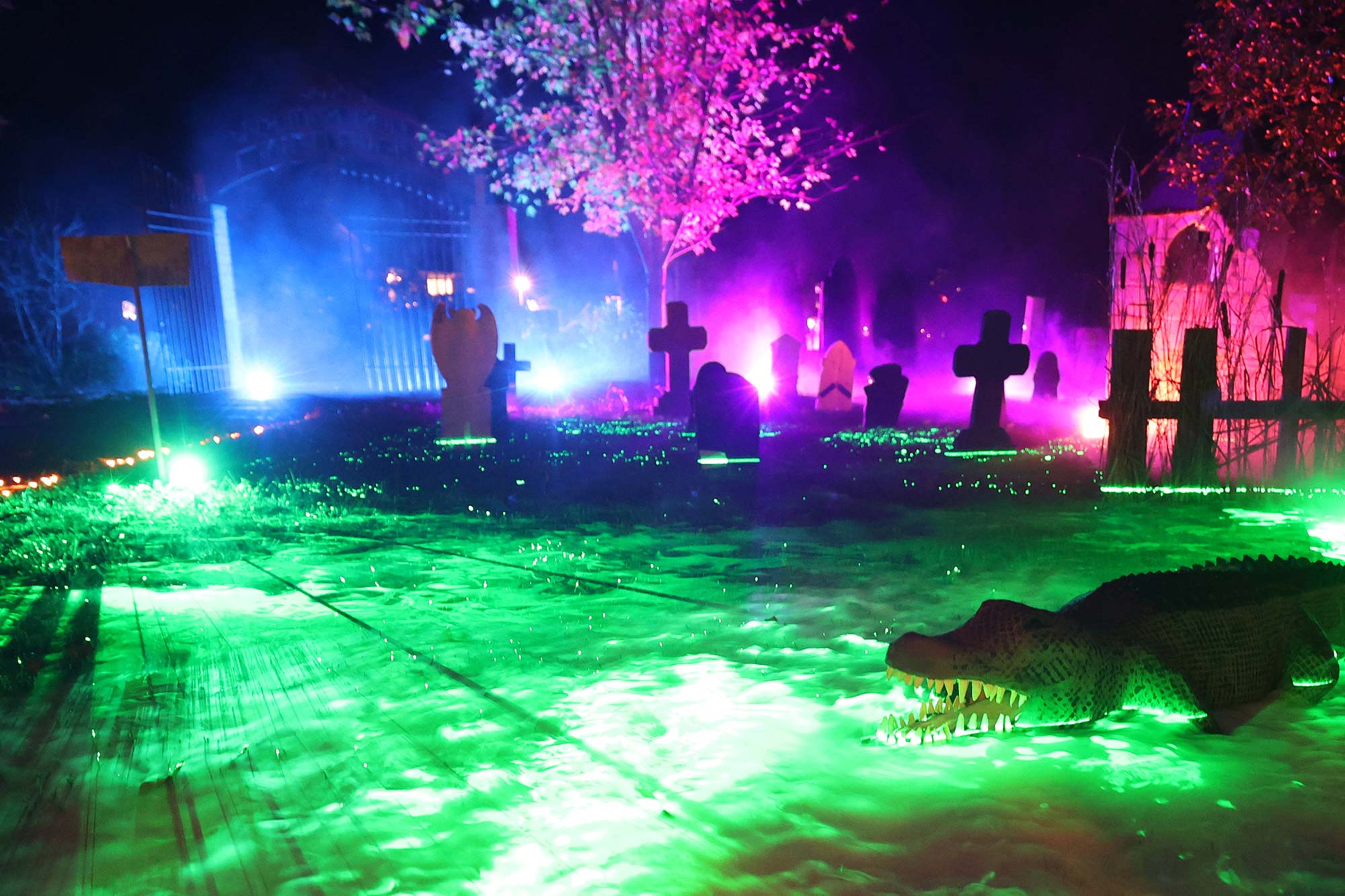 A gator among graves in a glowing swampland.