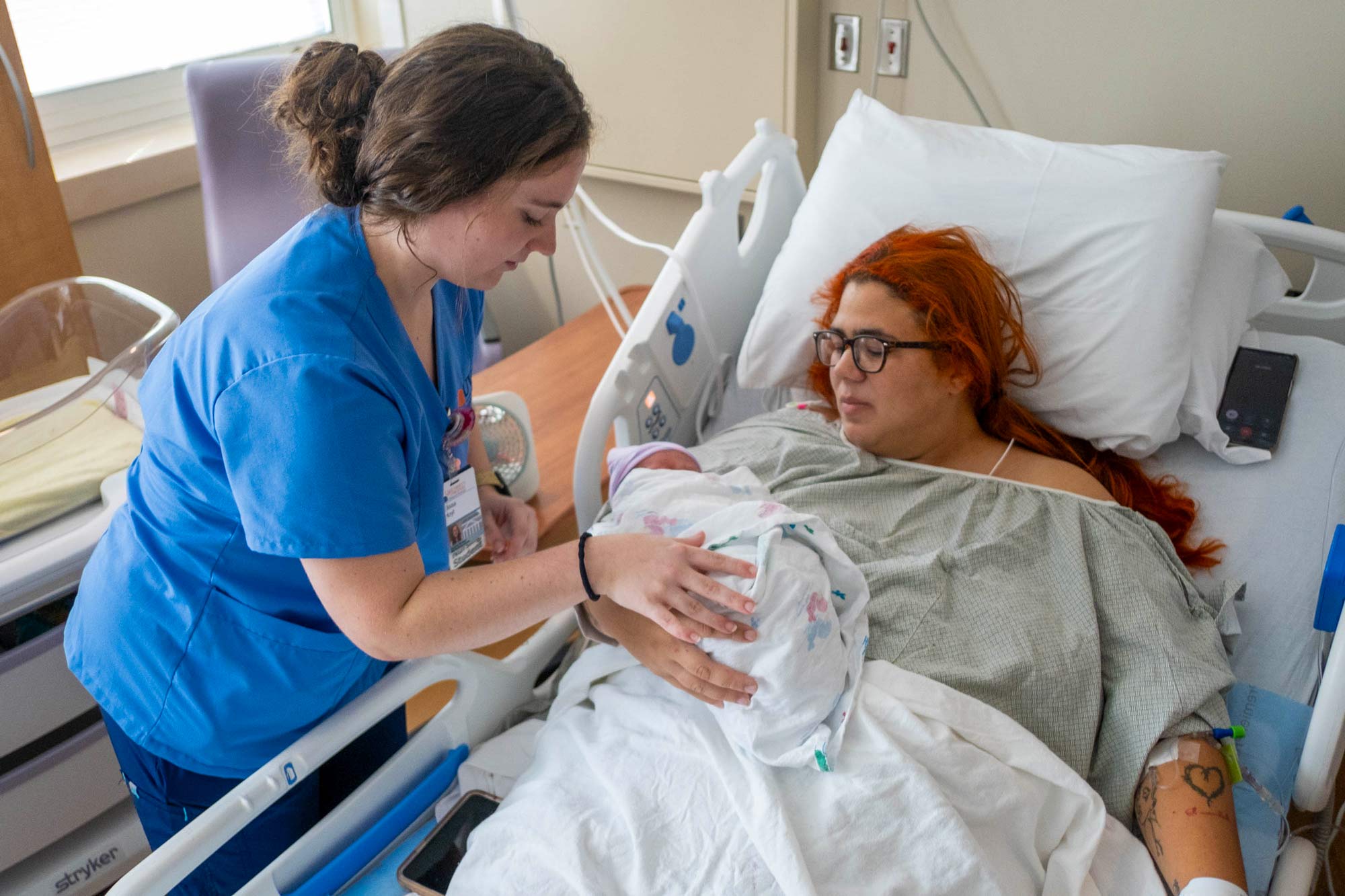 a UVA nurse places a newborn baby in her mother's arms