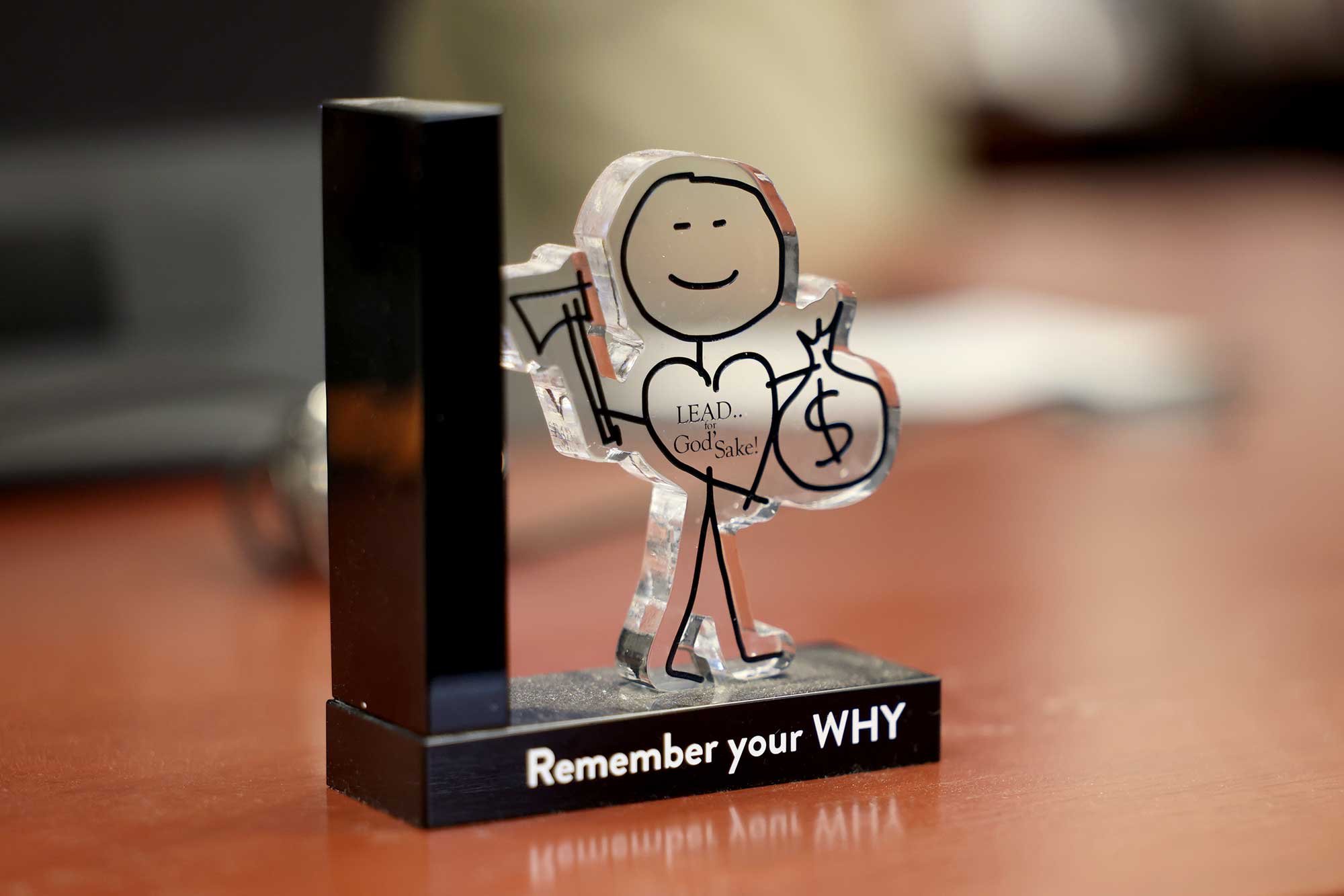 A small paperweight like statue that says remember your why and lead for God's sake!