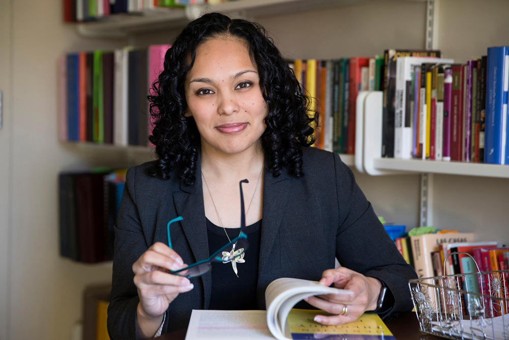 portrait of Nichole Flores reading in a UVA Library