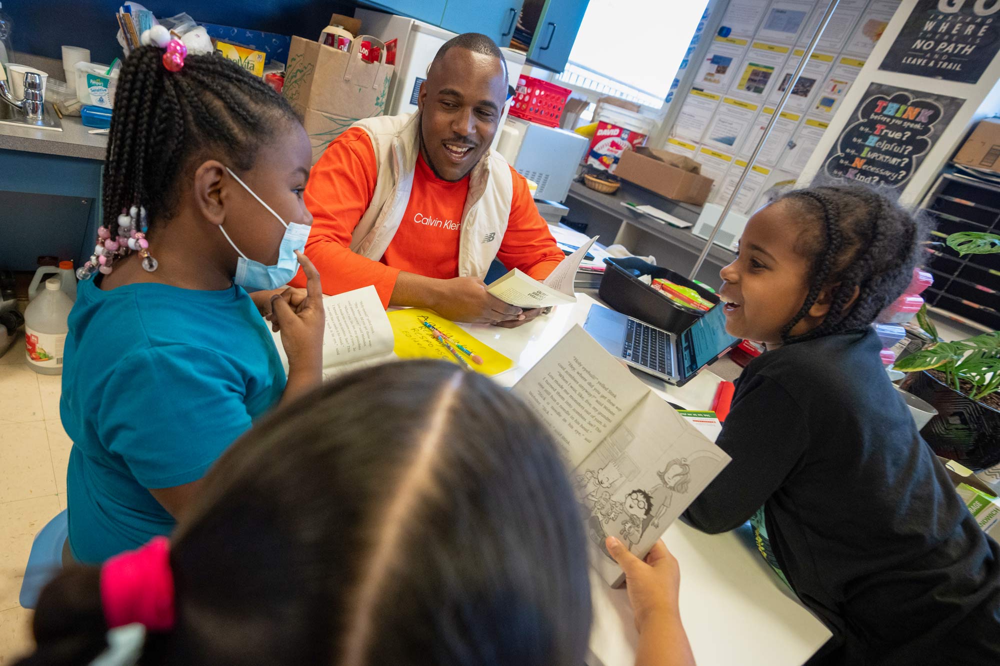 a teacher and 3 students all read and discuss a book together
