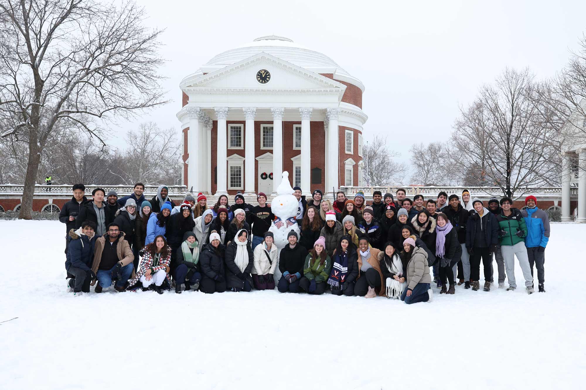 A group photo of students in front of the snowy Rotunda