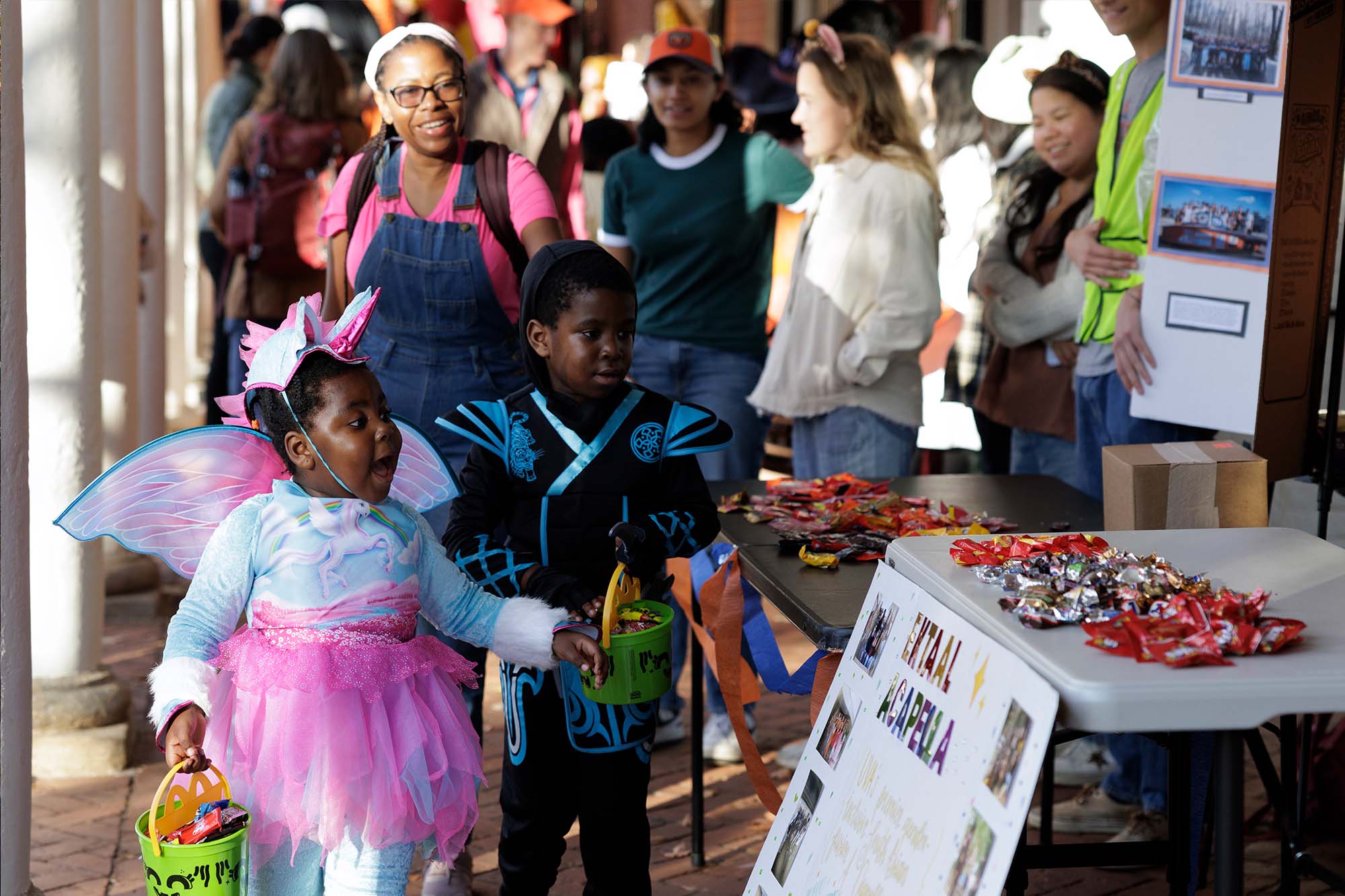 Area children, including a girl dressed as a flying unicorn and a boy dressed as a ninja, express their excitement over the treats and decorations of the Lawn rooms.