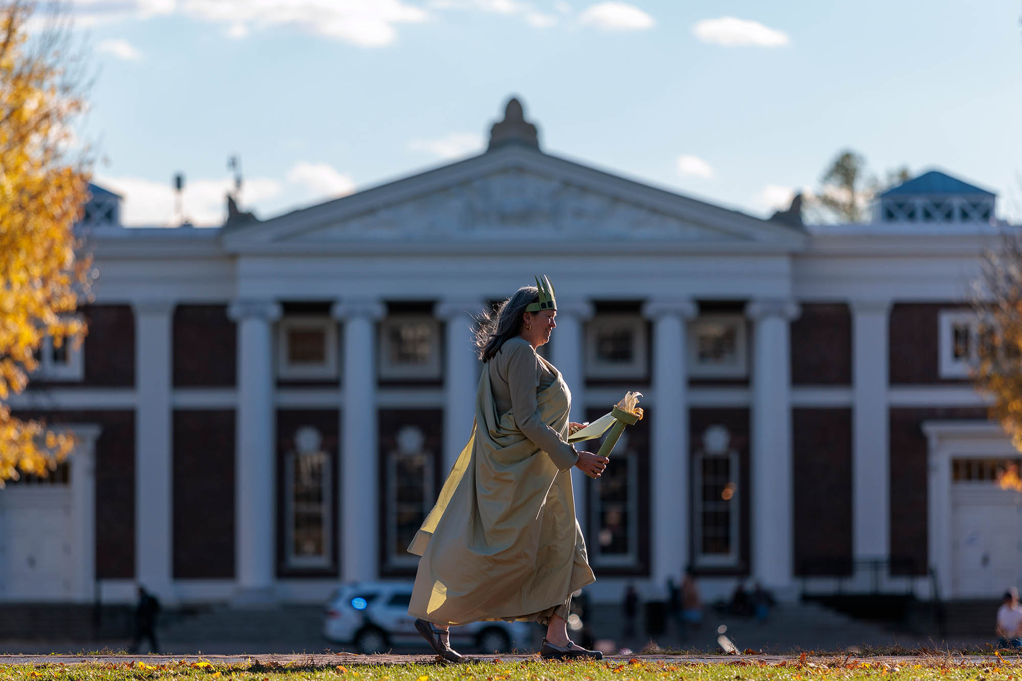 A woman dressed as the Statue of Liberty crosses the Lawn in front of Old Cabell Hall.