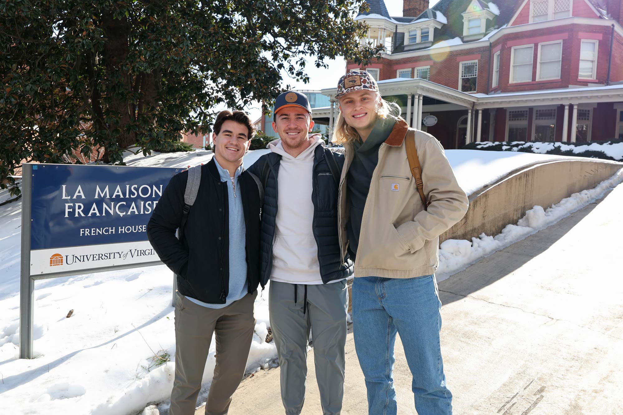 Three students stand outside of a UVA building