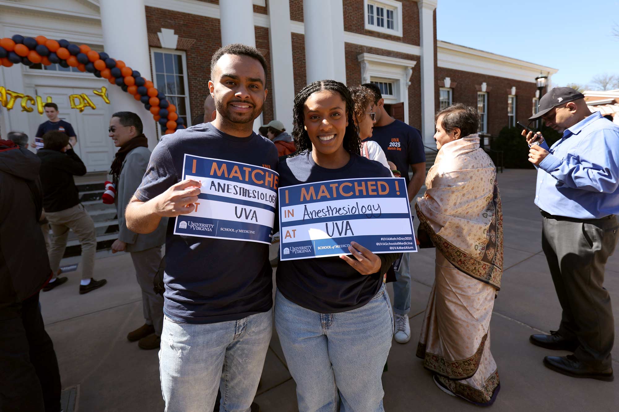 Two students holding up their Match Day signs