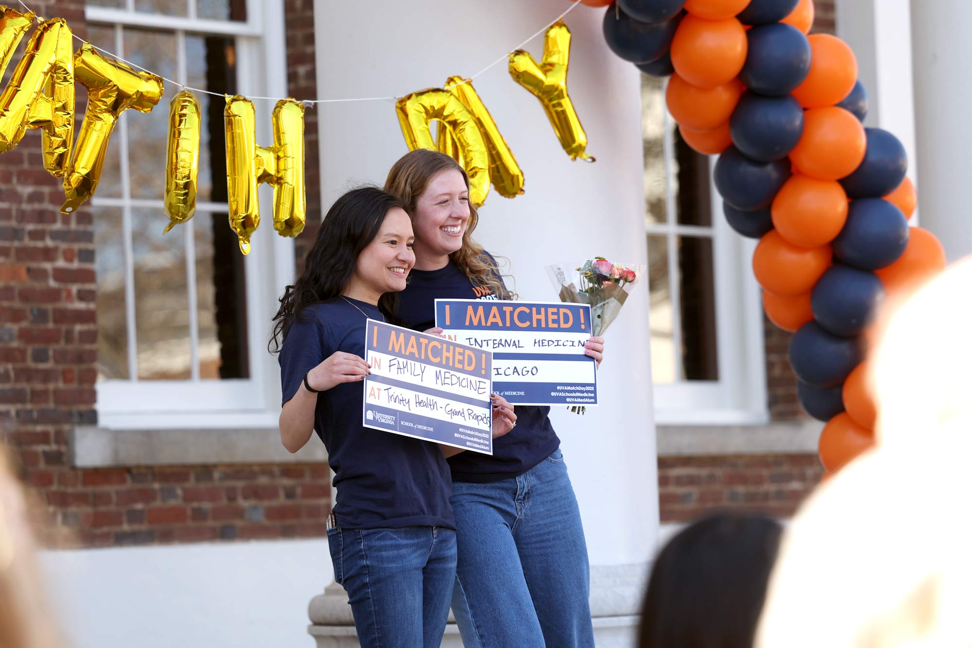 Two students holding up their Match Day signs