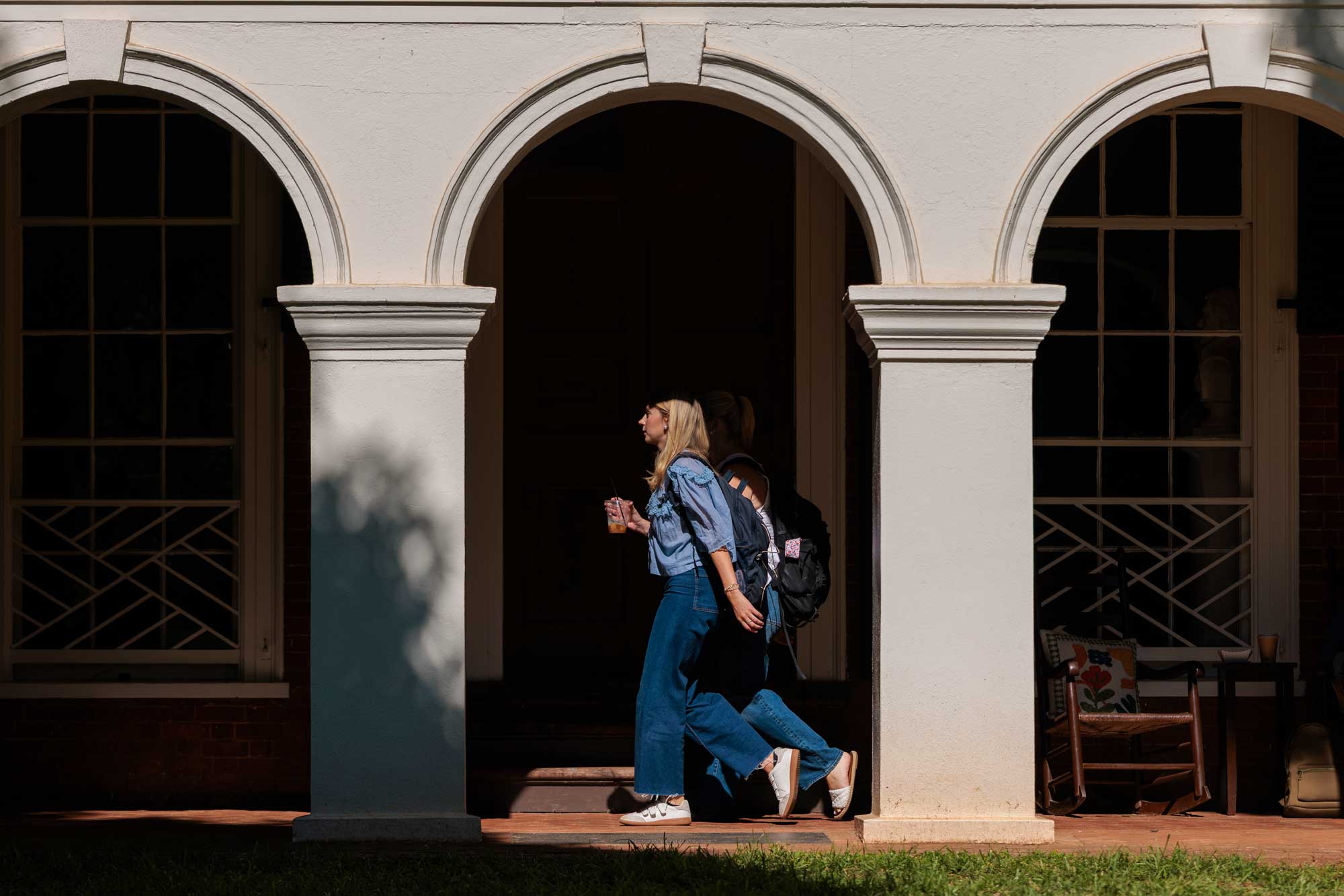 students walking under the colonnade of the Lawn on Grounds at UVA