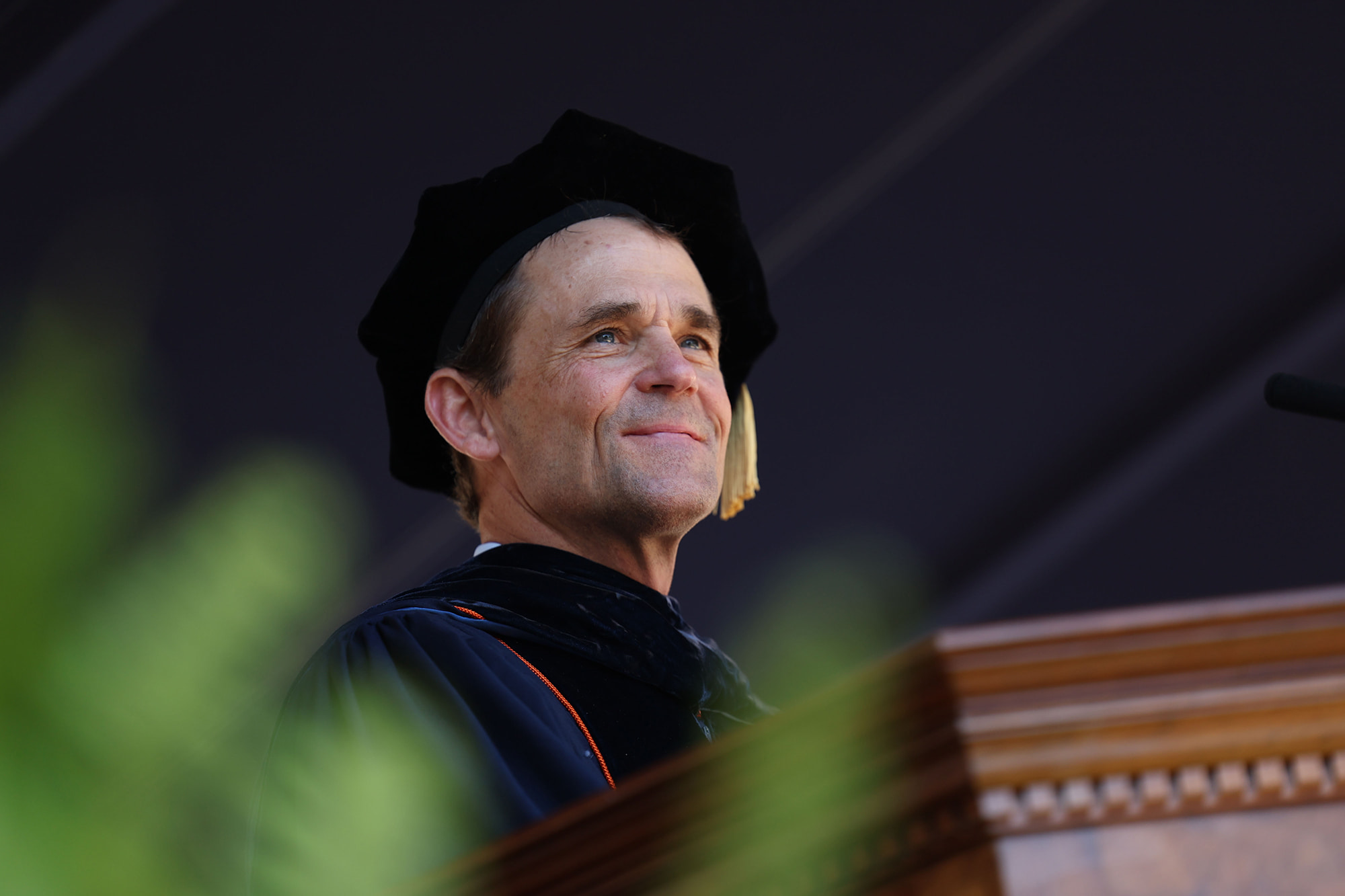 UVA President Jim Ryan smiling from the podium while giving a speech at UVA’s “Final Exercises 2025”