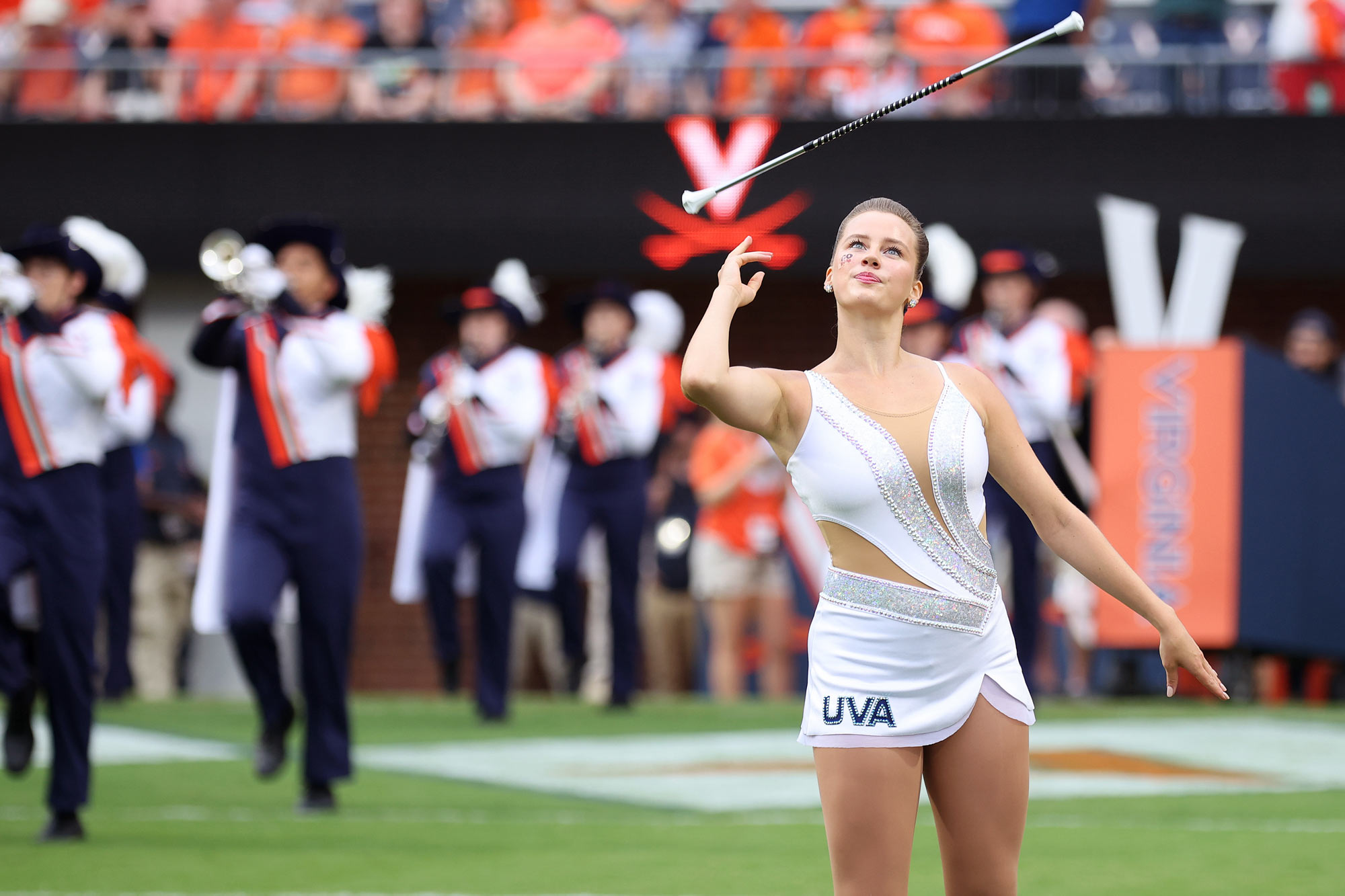 Madison Salber twirling a baton in front of the Cavalier Marching Band at a UVA football game