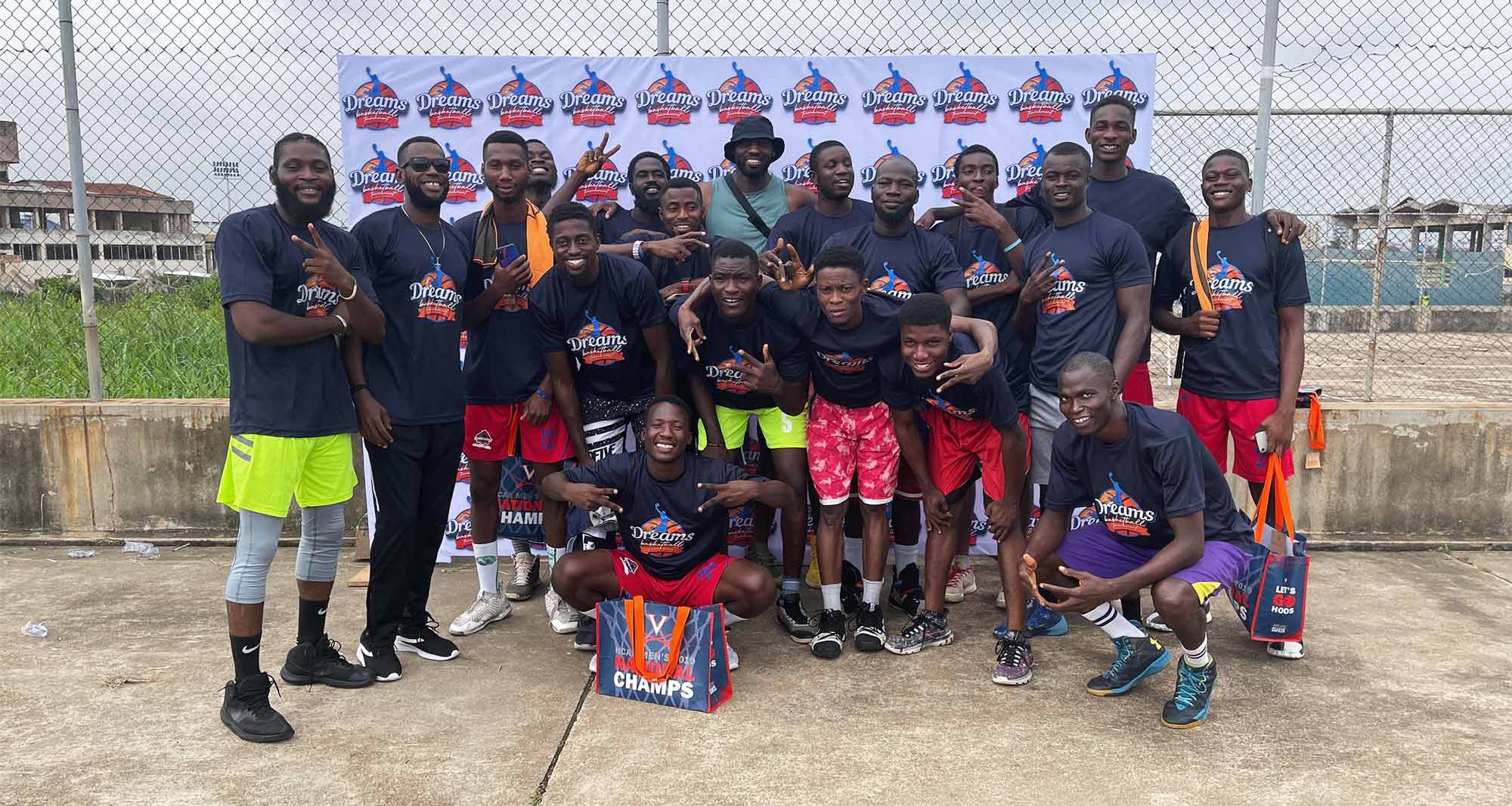 Soroye poses for a group photo with 18 men in team t-shirts